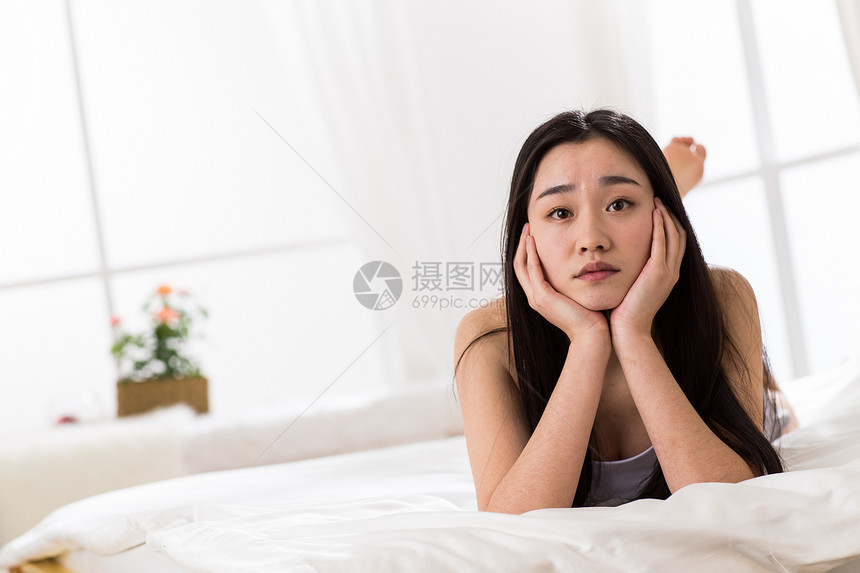 挫败不高兴的情绪压力青年女人坐在床上图片