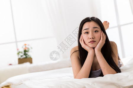 挫败不高兴的情绪压力青年女人坐在床上图片