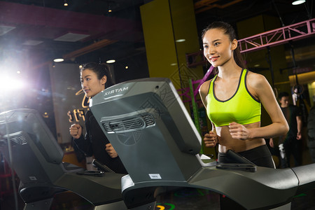 体育器材两个人塑身青年女人在健身房健身图片