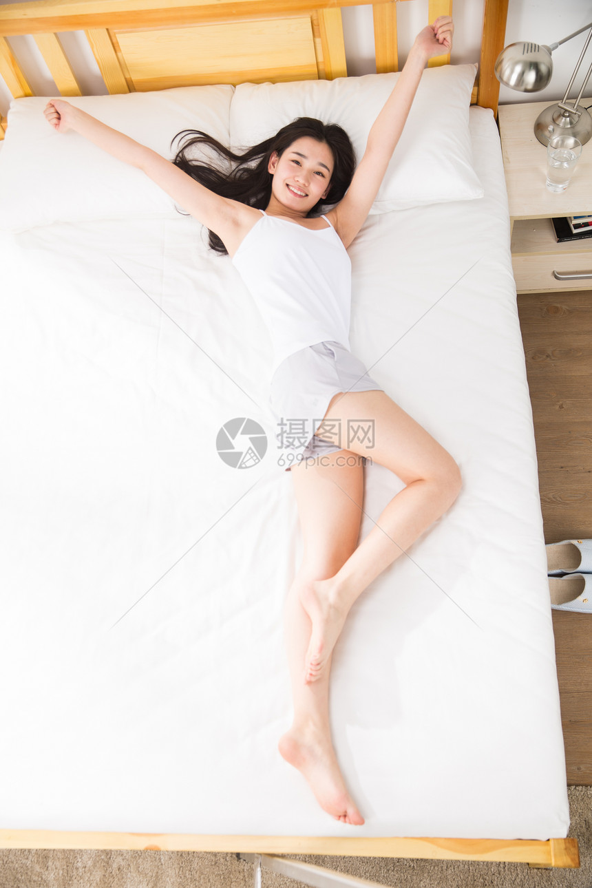东方人美女伸展青年女人躺在床上图片