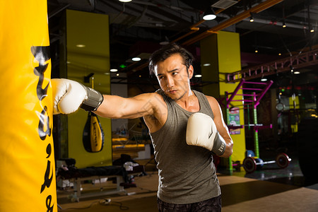 拳手套青年人运动休闲装青年男人在健身房里健身背景