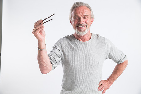 胡子元素乐趣成就影棚拍摄老年男人拿着筷子背景