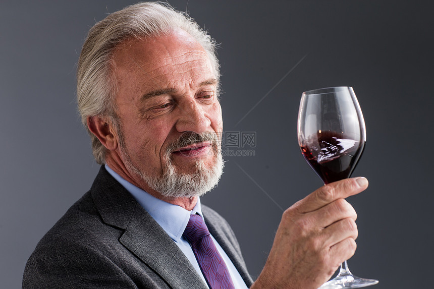 喝红葡萄酒的商务老年男人图片