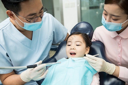 信任医疗流程户内男牙医和女牙医助手在为小女孩检查牙齿图片