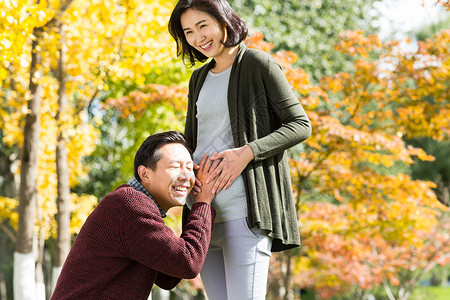 公园周末活动幸福丈夫陪着怀孕的妻子在户外图片