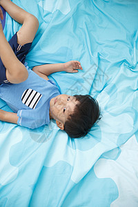 摄影床上用品学龄前儿童可爱的小男孩在床上玩耍图片