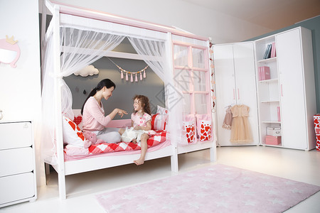 住宅内部床女儿可爱的小女孩和妈妈在卧室玩耍图片