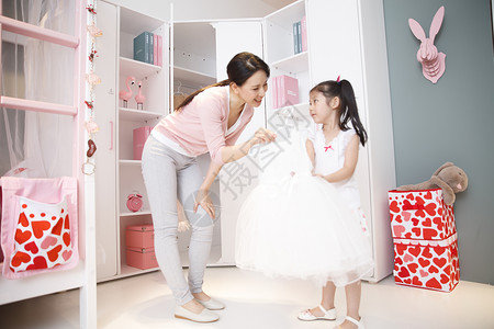 表现积极家卧室可爱的小女孩和妈妈玩耍图片