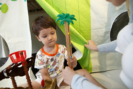 住宅内部乐趣放松可爱的小男孩和指导教师在游戏室玩耍图片