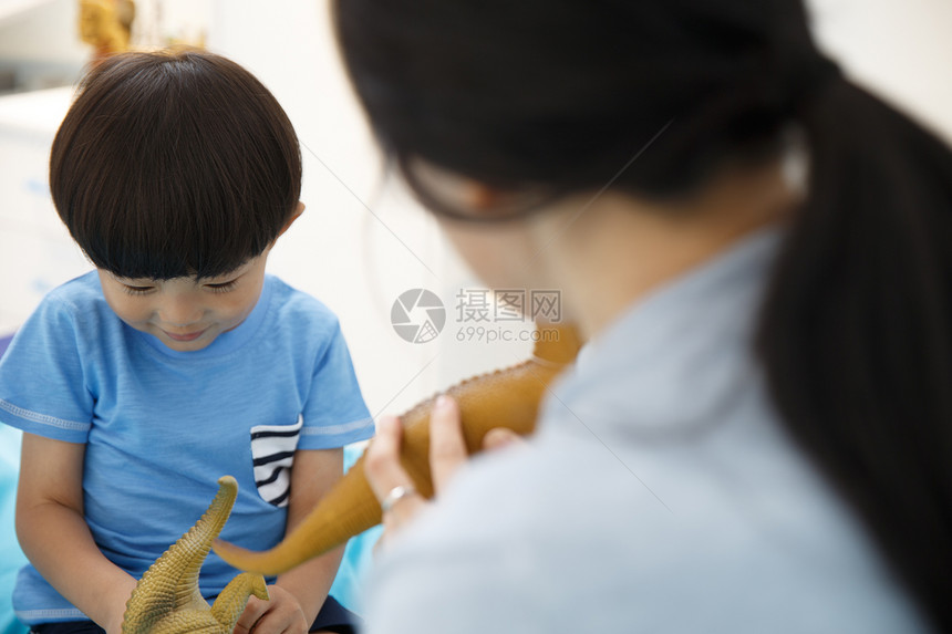 中年女人相伴嬉戏的可爱的小男孩和妈妈在卧室玩耍图片