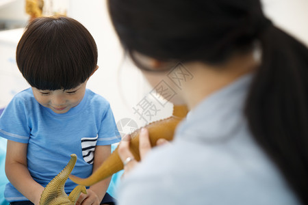 中年女人相伴嬉戏的可爱的小男孩和妈妈在卧室玩耍图片