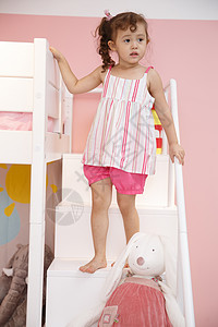 家庭休闲装混血儿可爱的小女孩在卧室玩耍图片
