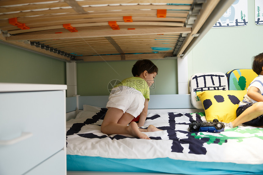 住宅内部英国人东方人两个小男孩在卧室玩耍图片