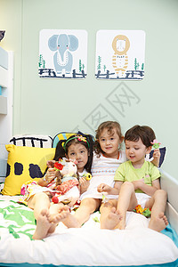 发饰休闲相伴欢乐的儿童在床上玩耍图片