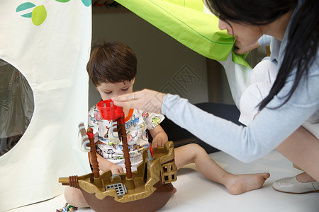 玩海盗船男孩乐趣两个人休闲可爱的小男孩和指导教师在游戏室玩耍背景