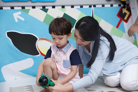 彩色游戏机漂亮的无忧无虑彩色图片可爱的小男孩和指导教师在游戏室玩耍背景