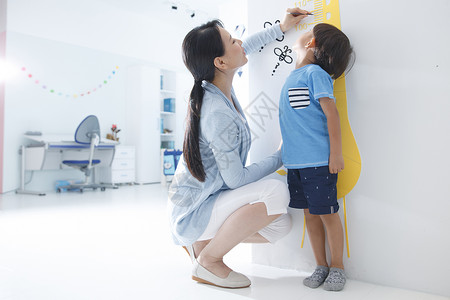 写在墙上的标语中年女人住宅内部测量工具妈妈在为小男孩测量身高背景
