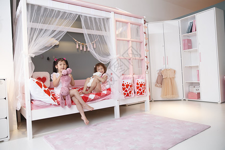 床柔和5到6岁可爱的小女孩在卧室玩耍图片