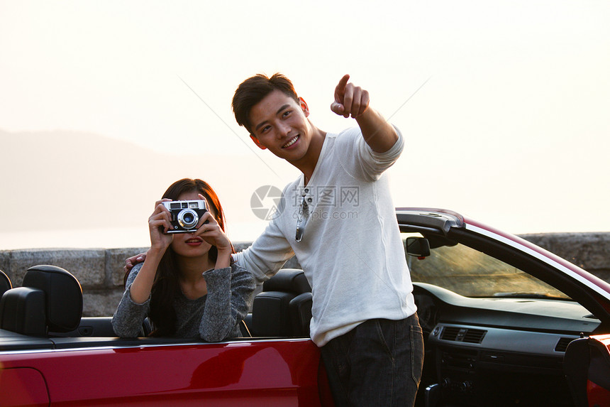 驾驶山路东亚青年男女开车出去旅行图片