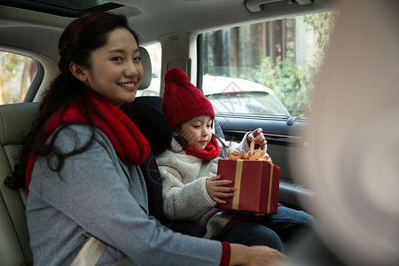 节日安全防护彩色图片喜庆女孩母亲和女儿乘车回家背景