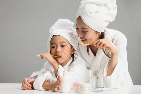 微笑房间女人穿着浴袍的母女刷牙图片