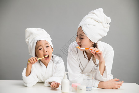 住宅房间人童年穿着浴袍的母女刷牙图片