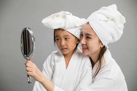活力拿着母亲穿着浴袍的母女照镜子图片