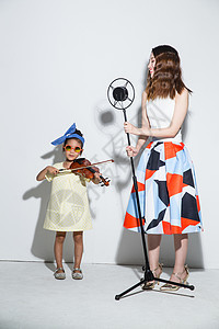 摄影优雅学龄前儿童小女孩和妈妈拉小提琴图片