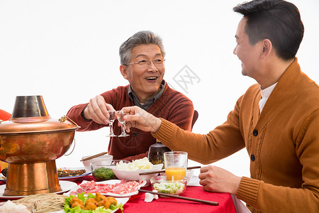 家庭气氛父子俩吃年夜饭喝酒背景