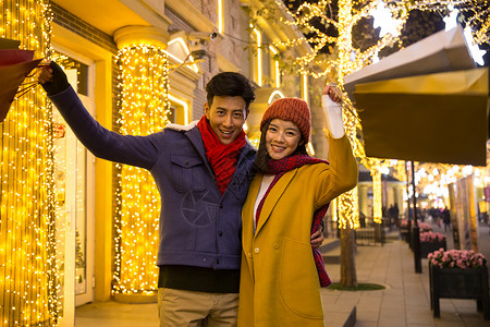 亚洲人街道节日青年情侣逛街购物图片