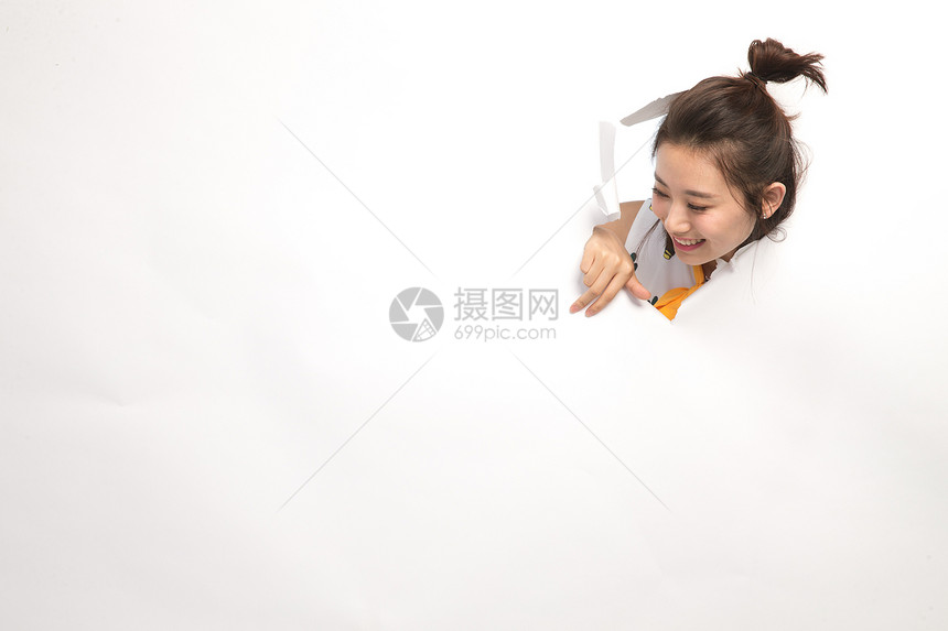 青年人东方人青年文化青年女人通过纸洞窥视图片