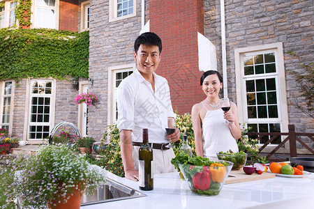 红酒器皿图标高雅的青年夫妇在户外厨房背景