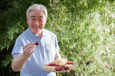 莲子百合银耳羹一个老年男人拿着干果背景