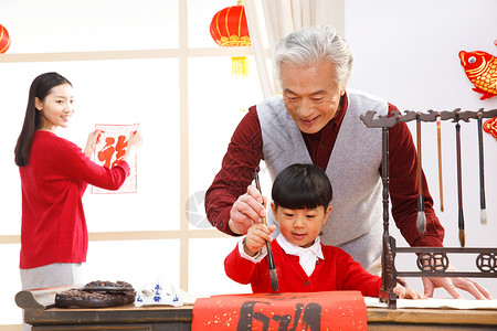 毛衣兴奋祖父快乐家庭过新年写春联图片