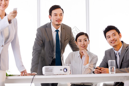 投影仪投影办公桌商务男女在会议室工作背景