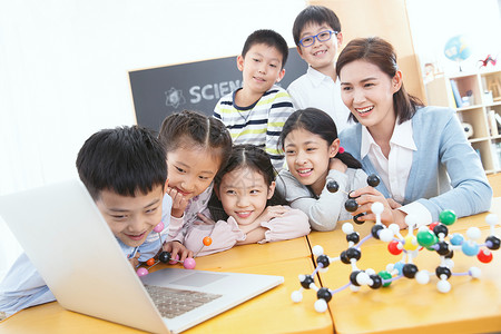 化学教师小学生在教室里使用电脑背景