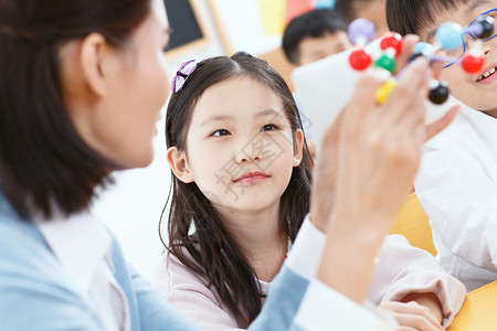 生物课程女教师和小学生在教室里背景