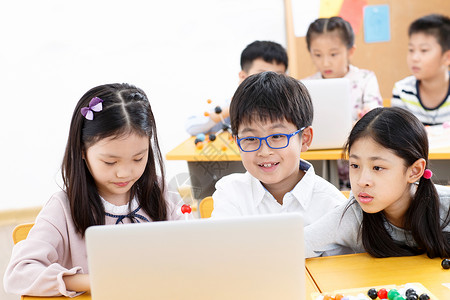 可爱的小学生在教室里使用电脑高清图片