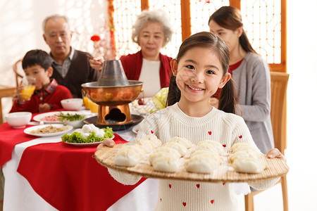 端着粽子的男孩母亲传统节日毛衣小女孩过年端着饺子背景
