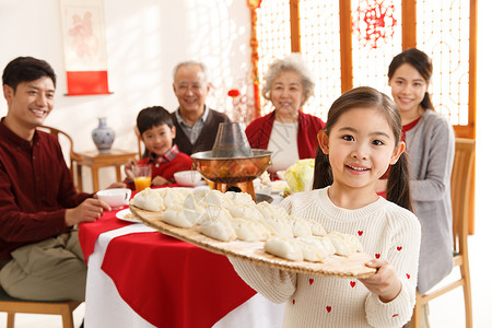 元素正面视角兴奋小女孩过年端着饺子图片