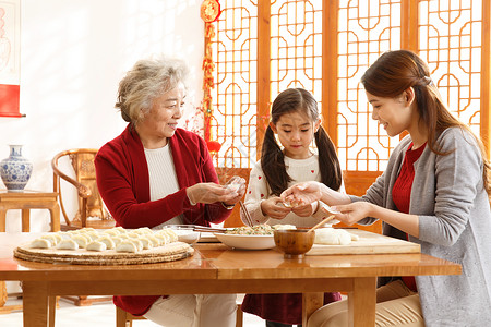 新年前夕春节青年女人幸福家庭过年包饺子图片