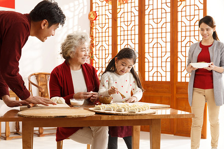 新年前夕青年人联系幸福家庭过年包饺子高清图片