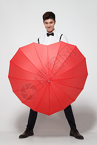 红色传统庆典时尚青年男人拿着心形红雨伞高清图片