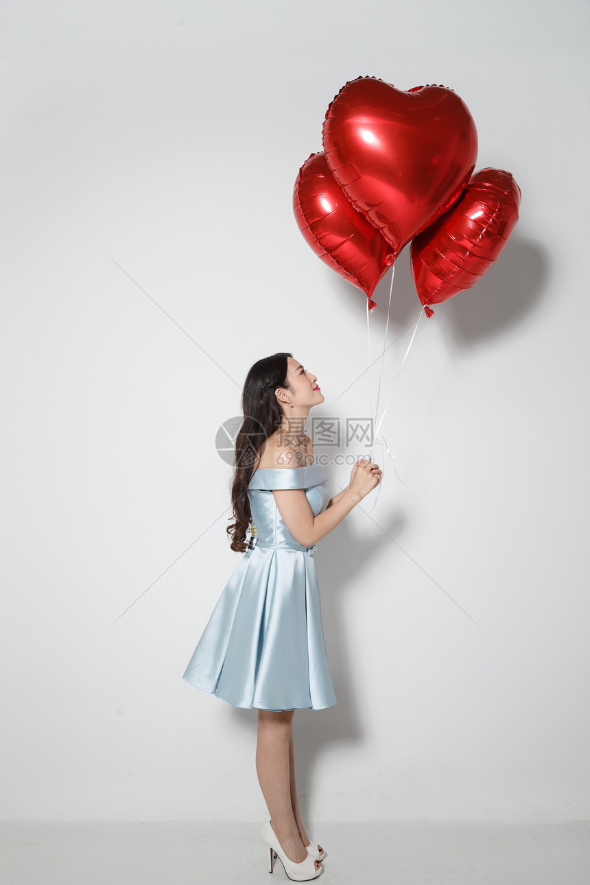 东方人关爱爱心青年女人拿着心形气球图片