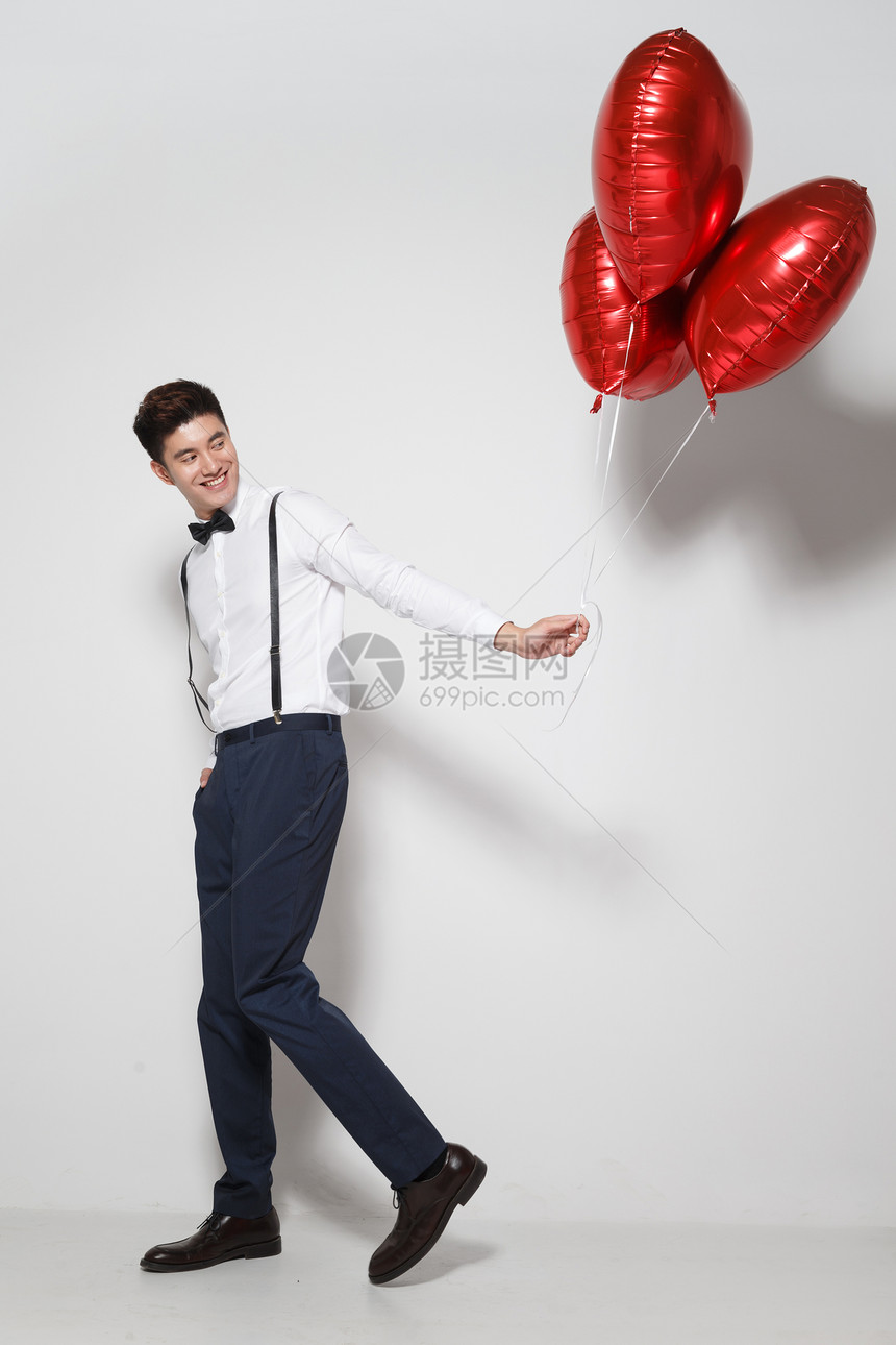 摄影享乐礼物青年男人拿着心形气球图片