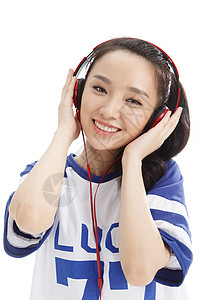 微笑户内肖像年轻女孩戴耳机听音乐图片