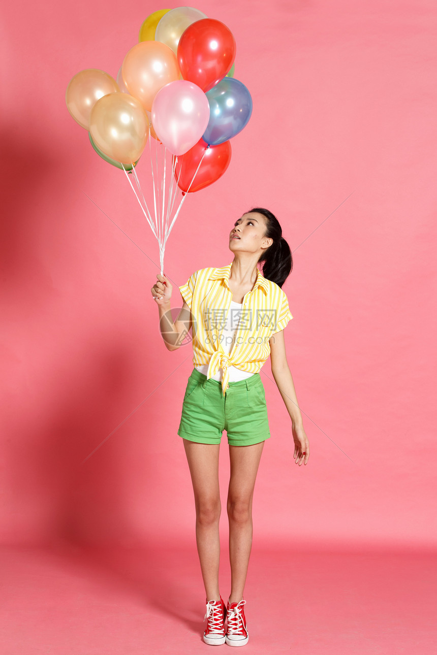 色彩鲜艳站着漂亮的人青年女人拿着气球图片