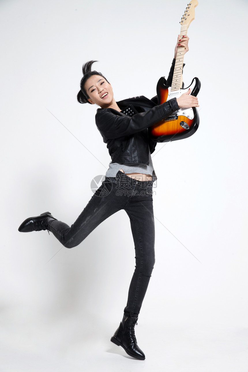 青年人歌手高兴的青年女人弹吉他图片
