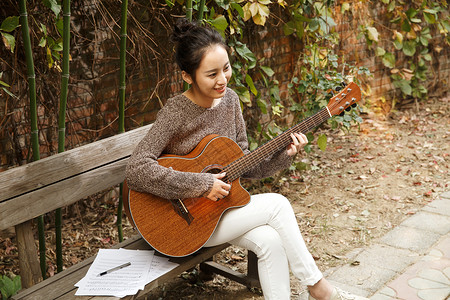 竹子水平构图年轻女人弹吉他图片