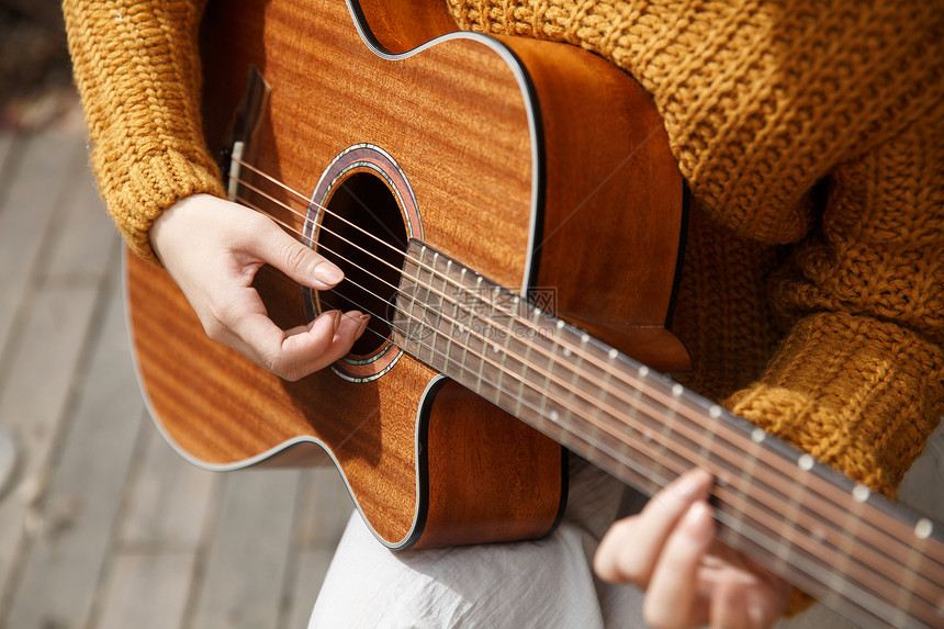 自由演奏放松年轻女人弹吉他图片